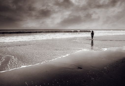 Dramatic landscape of single man walk at beach.