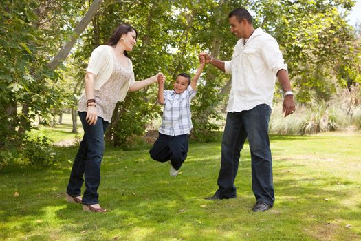 Hispanic Man, Woman and Child having fun in the park.