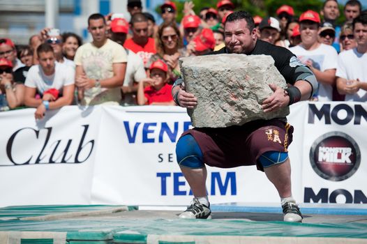 CANARY ISLANDS – SEPTEMBER 03: Alex Curletto from Italy lifting a heavy stone during Strongman Champions League in Las Palmas September 03, 2011 in Canary Islands, Spain