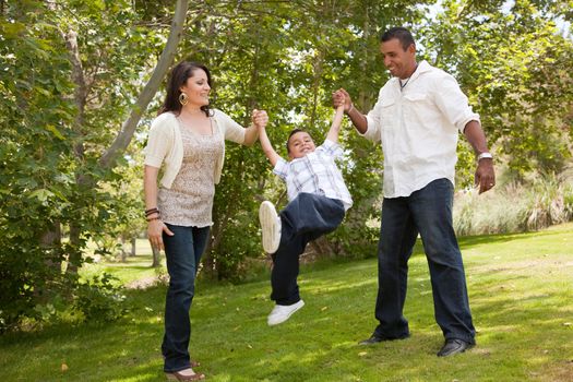 Hispanic Man, Woman and Child having fun in the park.