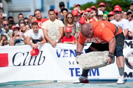 CANARY ISLANDS – SEPTEMBER 03: Ervin Katona from Serbia lifting a heavy stone during Strongman Champions League in Las Palmas September 03, 2011 in Canary Islands, Spain