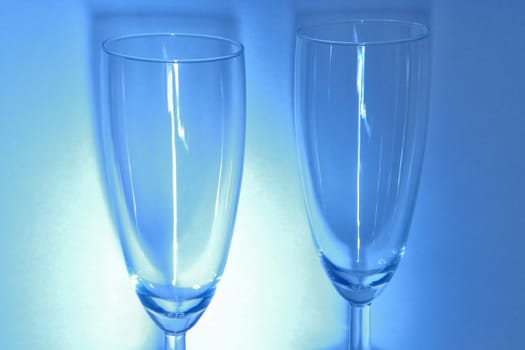 Glasses on the white and blue background with delicate shadow.