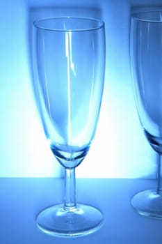 Wine glasses on the white and blue background with delicate shadow.