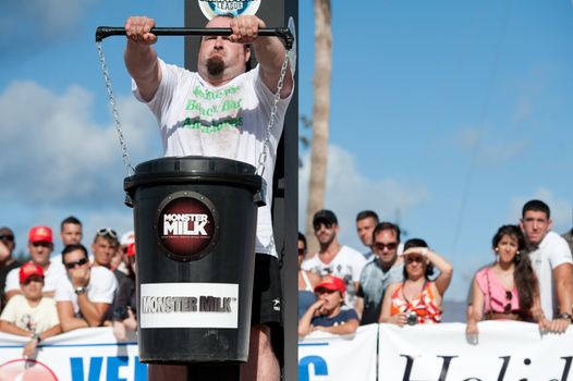 CANARY ISLANDS - SEPTEMBER 03: Julio Jimenez Zancajo from Spain lifting a heavy trash can for longest possible time during Strongman Champions League in Las Palmas September 03, 2011 in Canary Islands, Spain