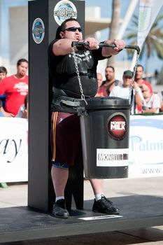 CANARY ISLANDS - SEPTEMBER 03: Warrick Brant from Australia lifting a heavy trash can for longest possible time during Strongman Champions League in Las Palmas September 03, 2011 in Canary Islands, Spain