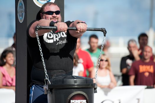 CANARY ISLANDS - SEPTEMBER 03: Warrick Brant from Australia lifting a heavy trash can for longest possible time during Strongman Champions League in Las Palmas September 03, 2011 in Canary Islands, Spain