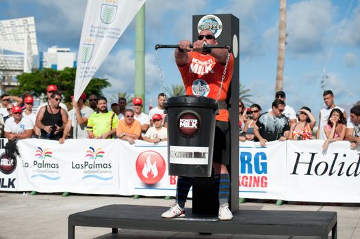 CANARY ISLANDS - SEPTEMBER 03: Ervin Katona from Serbia lifting a heavy trash can for longest possible time during Strongman Champions League in Las Palmas September 03, 2011 in Canary Islands, Spain