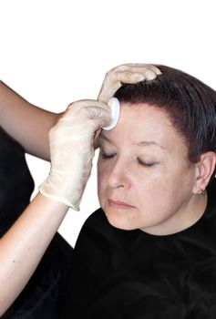 Close up portrait of woman with eyes closed receiving facial cleaning