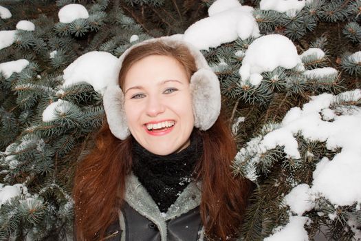 We see smiling young lady in the forest.