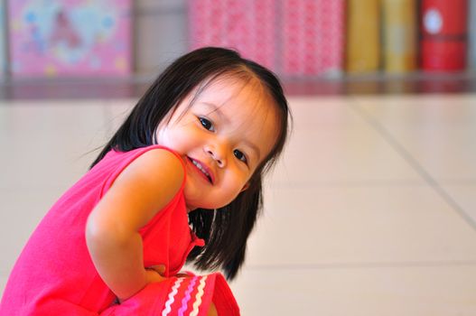 A happy , smiling little girl wearing a pink dress