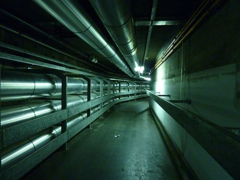 Underground tunnel with metallic pipes on both walls