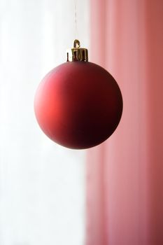 Decorative Christmas red ball over white and pink back