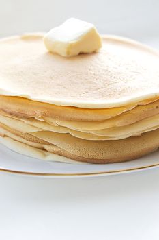 Pile of pancakes with butter on plate