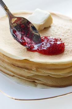 Pancakes with jam and spoon on a plate
