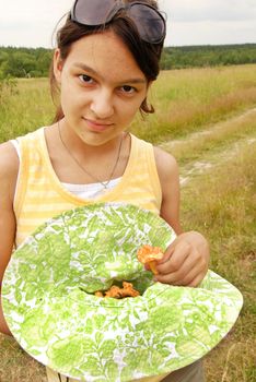 portrait of young smiling teenage caucasian girl outdoors with chanterelle mushrooms