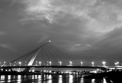 Dramatic cityscape of beautiful bridge over the river with lights reflection.
