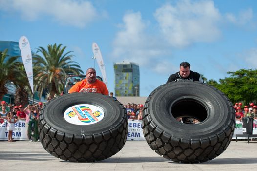 CANARY ISLANDS-SEPTEMBER 3: Ervin Katona (l) from Serbia and Arno Hams from Holland (r) lifting a wheel during Strongman Champions League in Las Palmas September 03, 2011 in Canary Islands, Spain