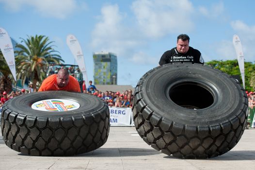 CANARY ISLANDS-SEPTEMBER 3: Ervin Katona (l) from Serbia and Arno Hams from Holland (r) lifting a wheel during Strongman Champions League in Las Palmas September 03, 2011 in Canary Islands, Spain