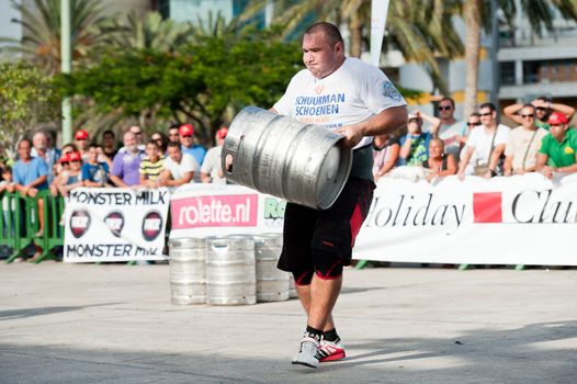CANARY ISLANDS - SEPTEMBER 03: Julio Jimenez Zancajo from Spain lifting and running with a heavy barrel during Strongman Champions League in Las Palmas September 03, 2011 in Canary Islands, Spain