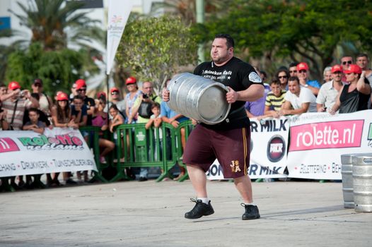 CANARY ISLANDS - SEPTEMBER 03: Alex Curletto from Italy lifting and running with a heavy barrel during Strongman Champions League in Las Palmas September 03, 2011 in Canary Islands, Spain