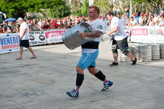 CANARY ISLANDS - SEPTEMBER 03: Tomi Lotta (m) from Finland lifting and running with a heavy barrel during Strongman Champions League in Las Palmas September 03, 2011 in Canary Islands, Spain
