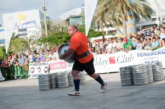 CANARY ISLANDS-SEPTEMBER 03: Ervin Katona from Serbia lifting and running with a heavy barrel during Strongman Champions League in Las Palmas September 03, 2011 in Canary Islands, Spain