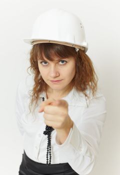 The beautiful girl - the engineer under safety precautions in a helmet