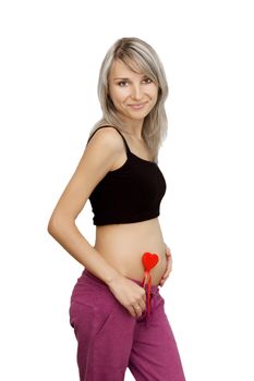 Pregnant woman holding red heart over white, first trimester