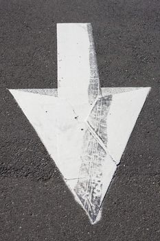 White Arrow With a Tread Mark Painted on The Gravel