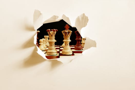 chess pieces behind hole in blank paper