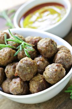 Fresh hot meatball appetizers served in white bowl with dipping sauce
