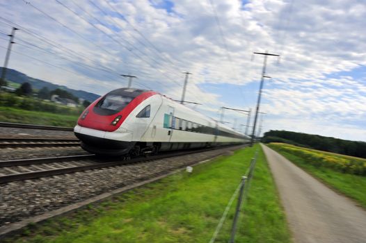 An inter-city express speeding through farmland.. Motion blur used to give sense of speed.
