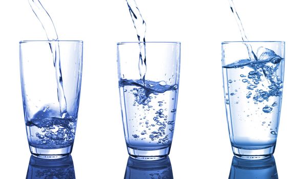 filling a glass of water isolated on white background