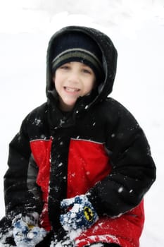 a boy stands out in the snow on a cold winter day