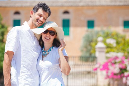 Closeup portrait of happy couple standing in front of the villa. Mallorca. Spain