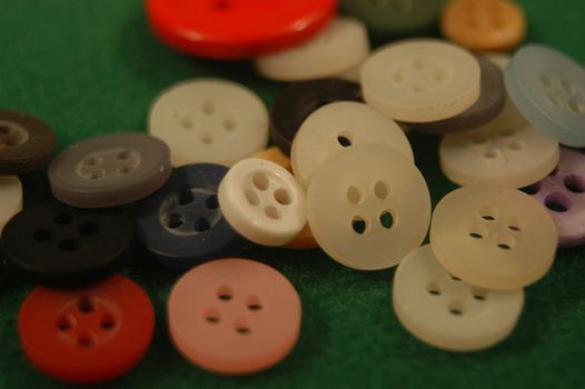 A pile of buttons on a field green