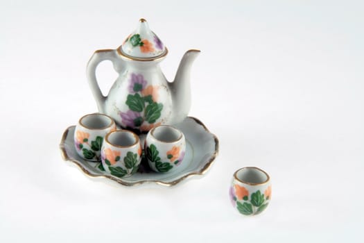 miniature teapot with four cups and a tray
