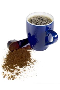 A coffee cup and a spoon spilling coffee powder