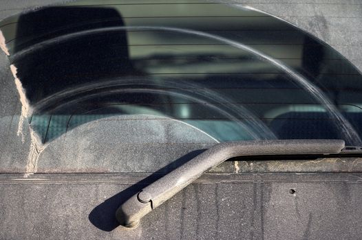 The dirty back window of an  automobile