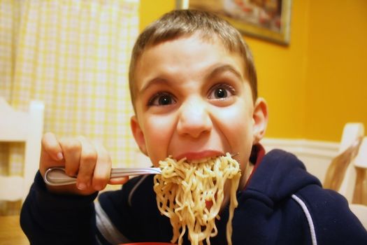 a goofy boy eating noodles
