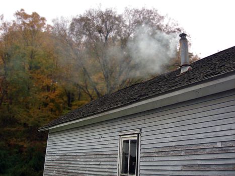 a smoky chimney on top of an old house