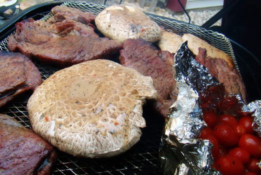 an ensemble of summer foods cooking on a grill