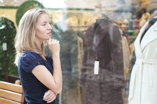 beautiful girl in the store smiling and thinking about shopping during the holidays