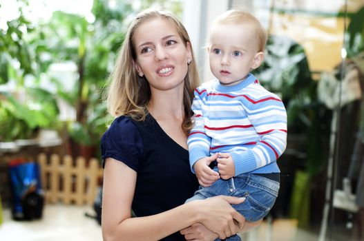 beautiful woman in the store smiling and hugs child