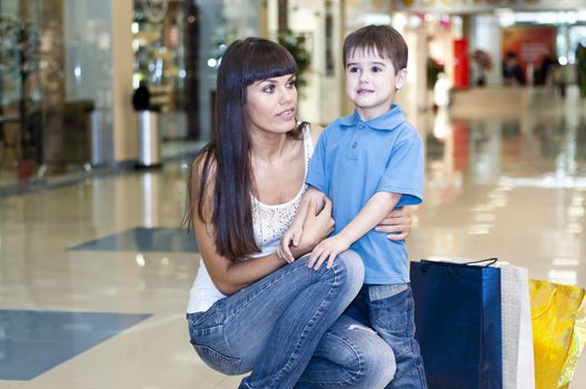 Mum and the son discuss purchases in shopping center