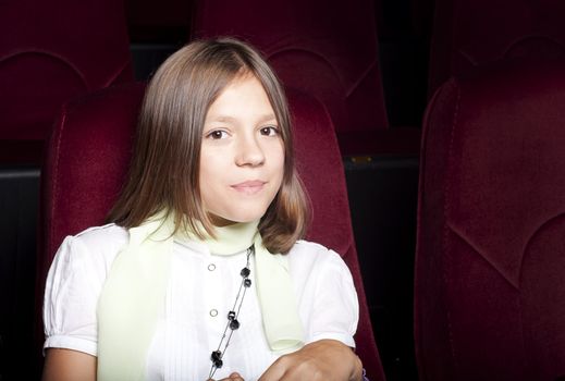 girl sitting alone in the cinema and watching a movie