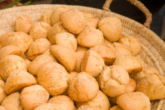 Sweet sesame buns in a wicker basket. Shallow DOF.