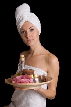 Woman with towel with spa products over black