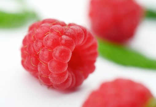 Raspberries with green leaves.This image is focused on one of them