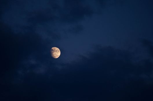 Waxing gibbous moon and dark clouds after sunset